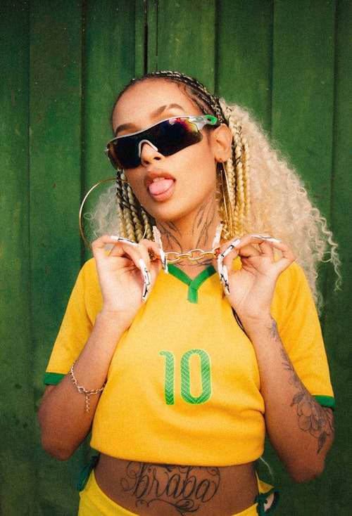 Woman in Brazilian Soccer Shirt Showing a Tongue