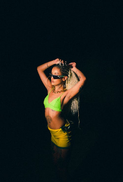 Blonde Woman in Green Bikini Bra and Yellow Little Skirt Posing in Studio