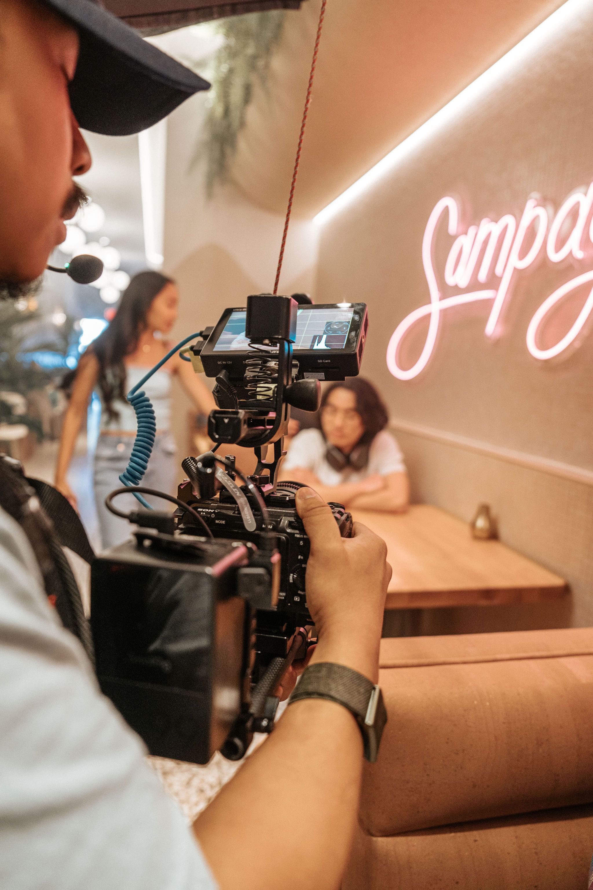 Capturing a candid moment during a photo session in an Orlando café with a neon sign backdrop.