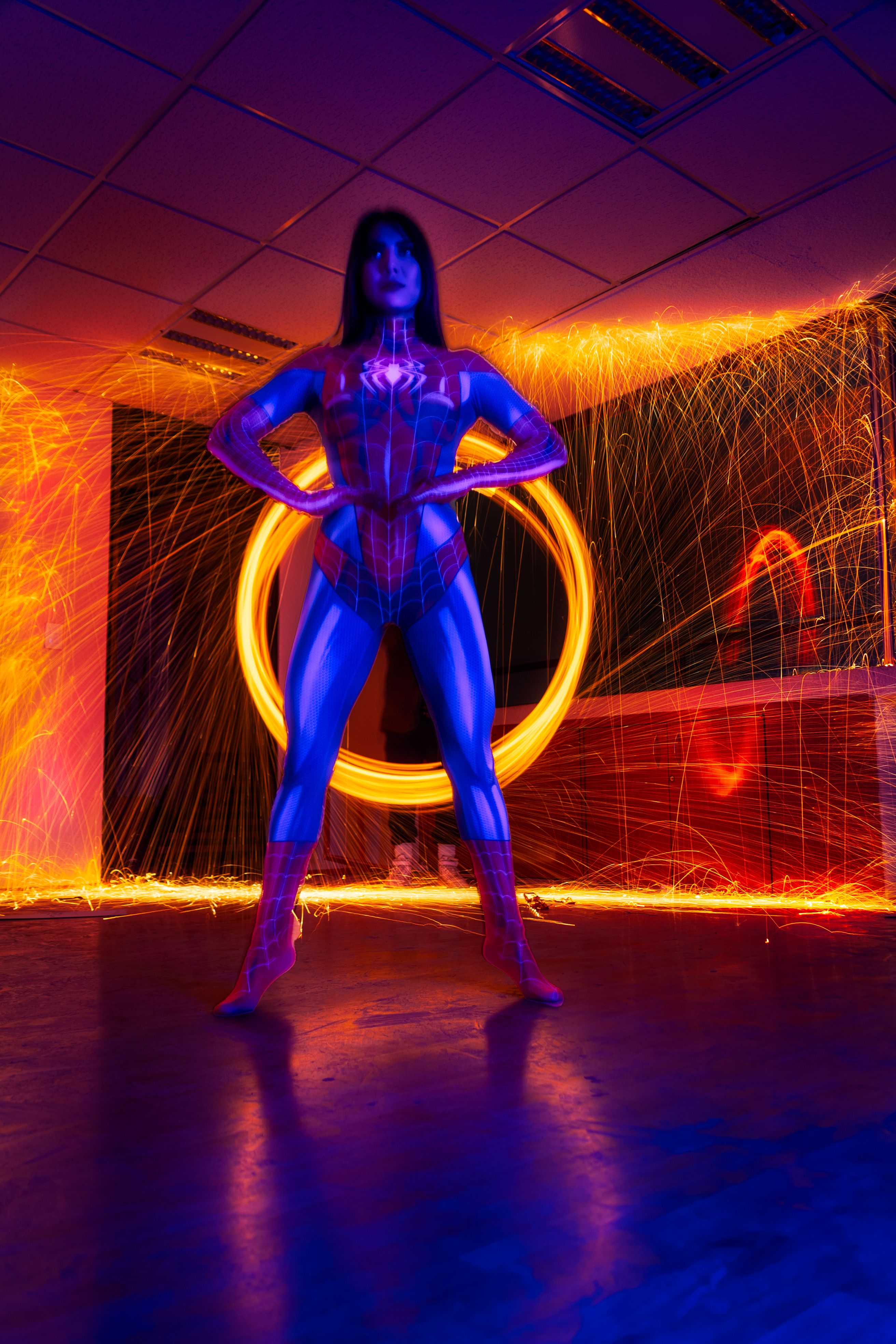 Dynamic portrait of a woman in superhero costume with vibrant light trails in Mexico City.