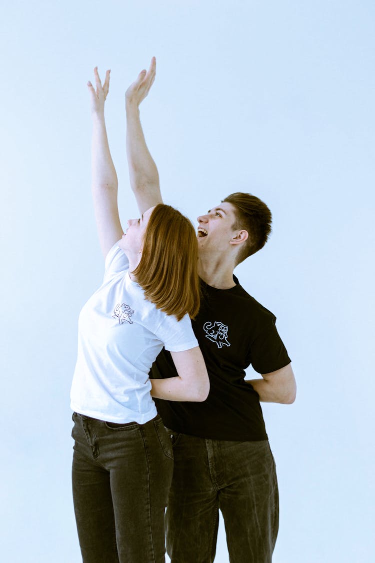 Couple Reaching Their Hands Into Air