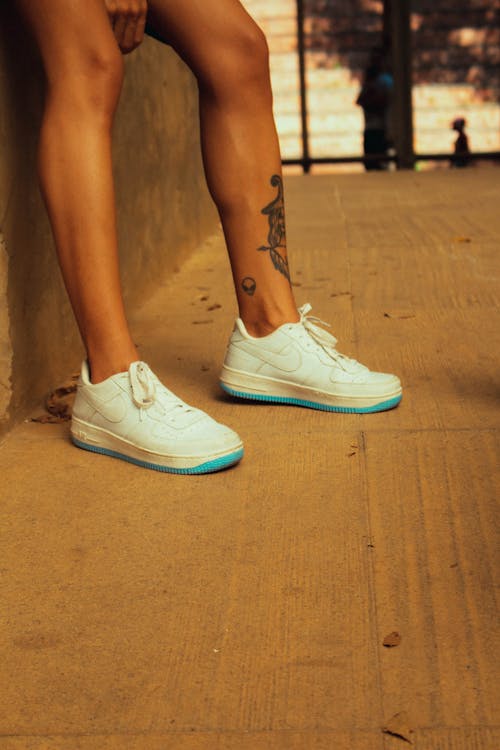 Women Legs with Tattoo and Sneakers