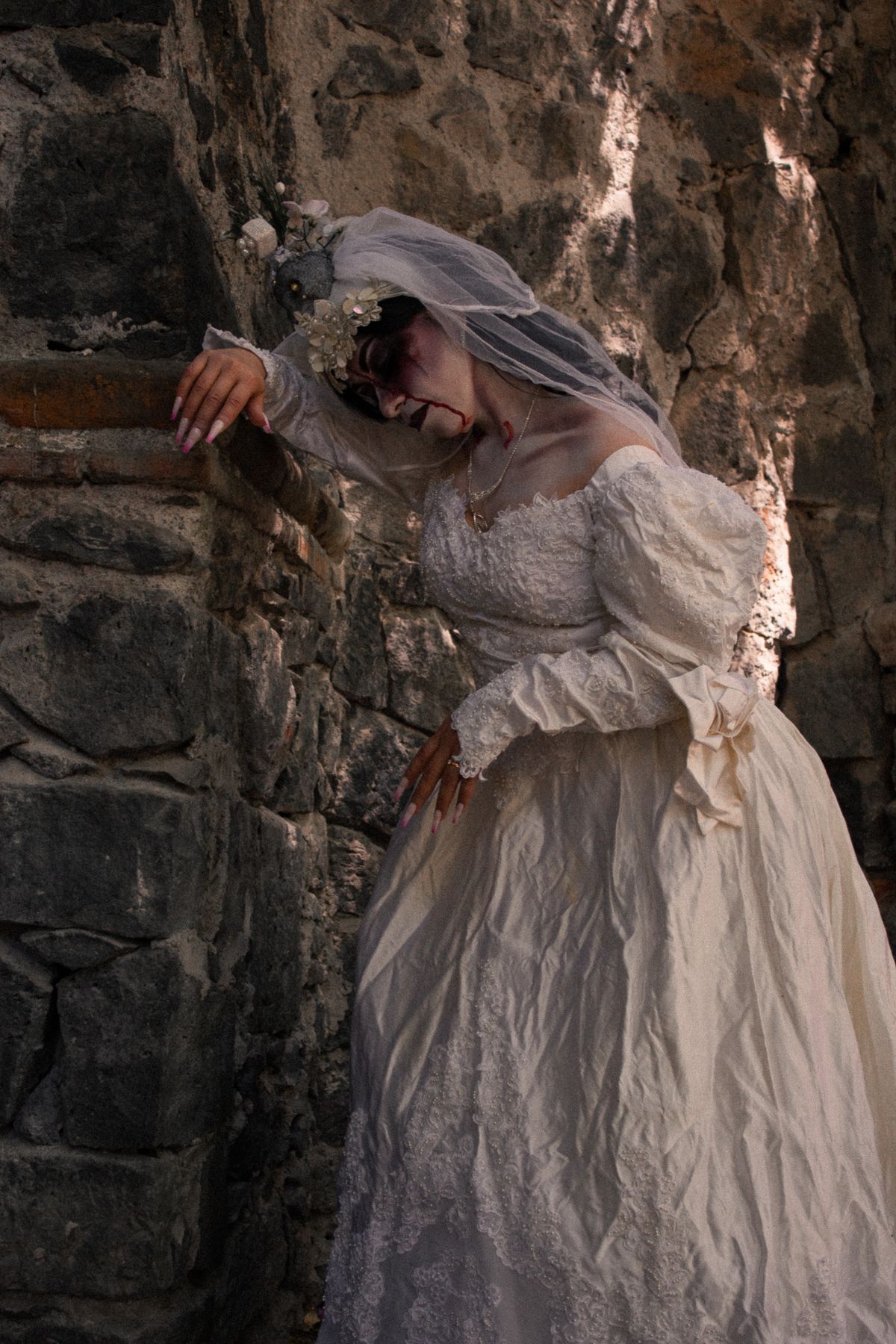 Adult woman in a long white dress with a veil and dark ghostly makeup for halloween costume ideas for adults