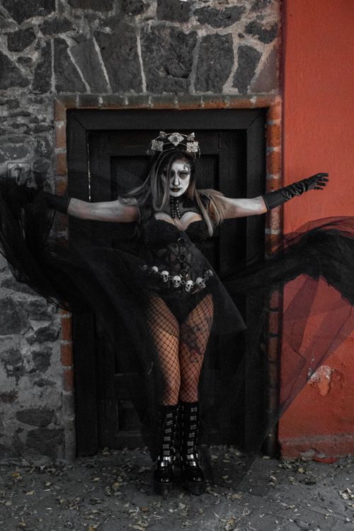 Free A young woman in gothic attire with dramatic face paint posing outdoors. Stock Photo