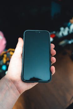 A detailed view of a hand holding a smartphone, emphasizing modern technology.