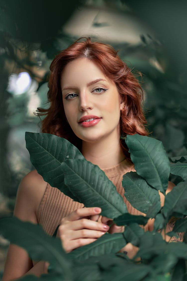 Portrait Of Woman Standing Behind Plant Leaves