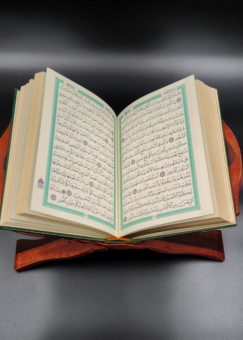 Free Open Quran displayed on wooden rehal inspiring spiritual reflection and learning. Stock Photo