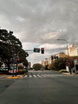 A bustling urban street in Buenos Aires with traffic lights and buildings lining the road.