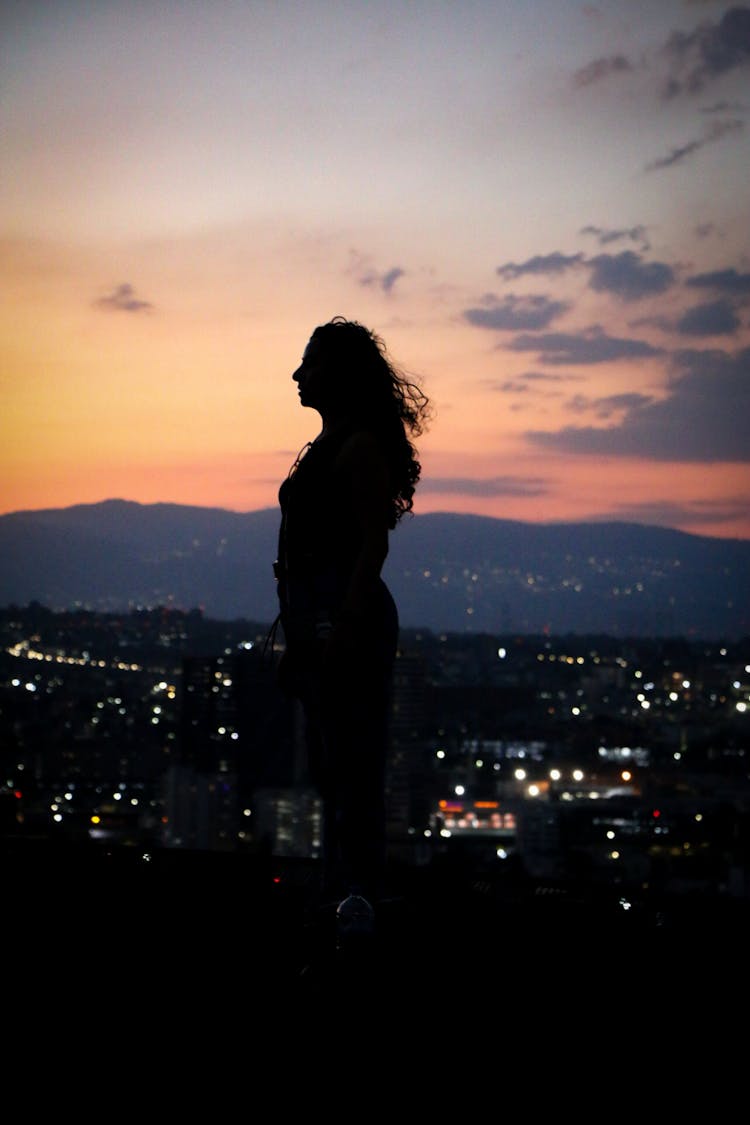 Silhouette Of Standing Woman At Sunset