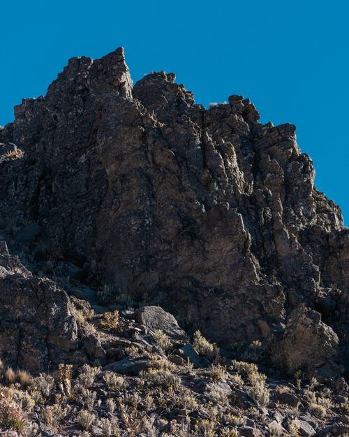 Free Vivid close-up of a rugged rocky cliff under a clear blue sky, showcasing natural beauty. Stock Photo