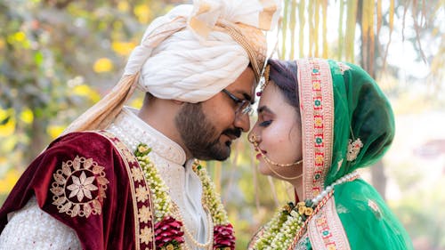 Bride and Groom in Traditional Clothing Posing with Faces Together