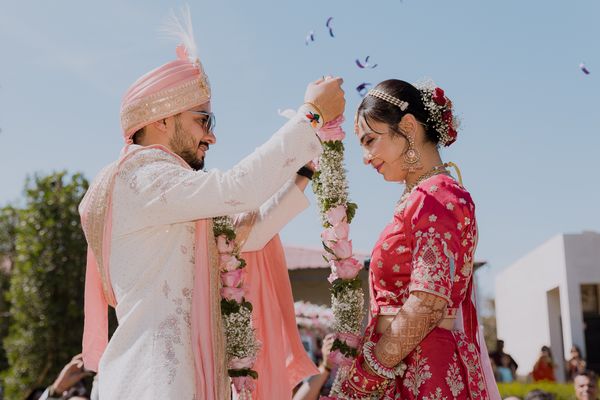 Indian wedding couple exchanging flower garlands