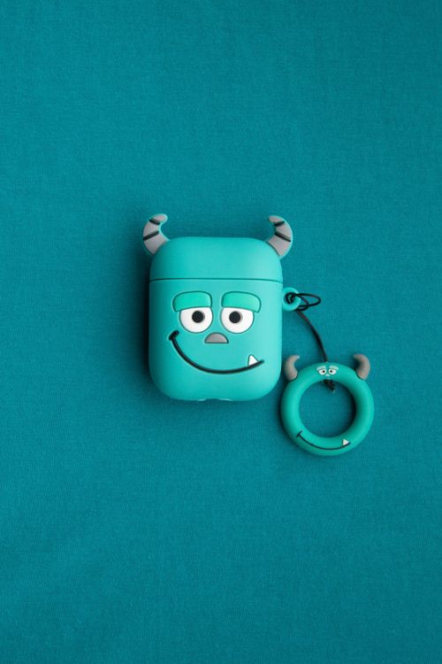 Free Playful monster-themed earphone case with cute charm on blue background. Perfect for kids. Stock Photo