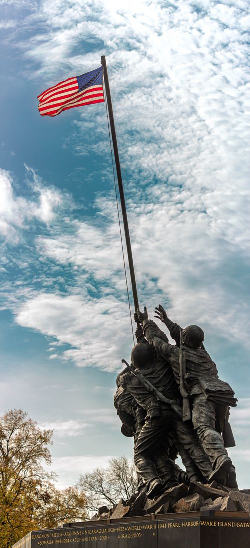 Free Vertical shot of the iconic Iwo Jima Memorial in Washington, D.C., USA, with American flag waving. Stock Photo