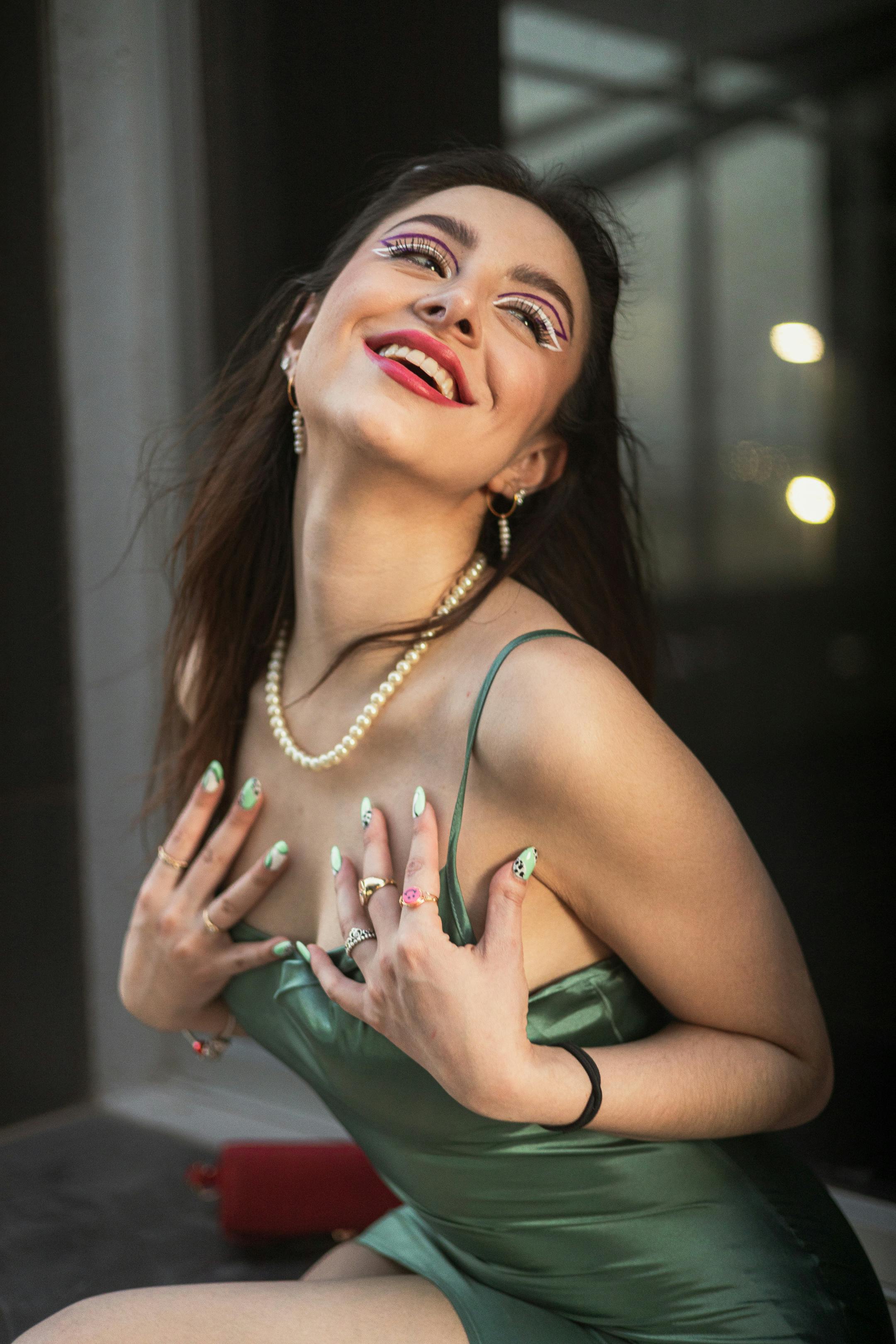 Free Glamorous young woman in a green dress with artistic makeup and jewelry. Stock Photo