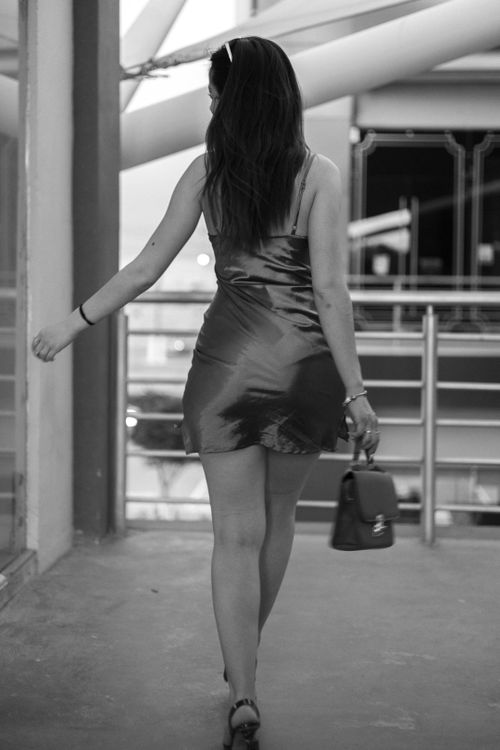Free Black and white photo of a woman in a dress walking indoors, showcasing fashion and elegance. Stock Photo