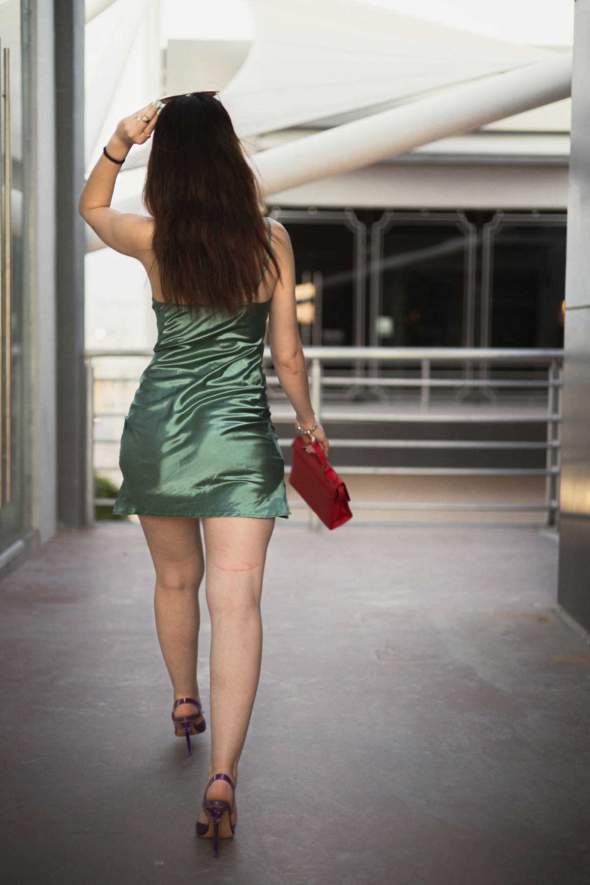 A woman in a short dress walking down a sidewalk · Free Stock Photo