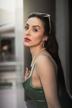 Stylish portrait of a woman wearing artistic makeup, elegant dress, and accessories, exuding charisma.
