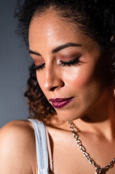 Close-up portrait of a woman with makeup and jewelry, showcasing beauty and fashion.