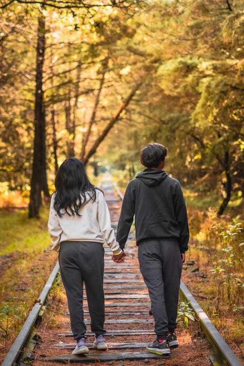 Back View of a Couple Walking on a Railway Track in an Autumn Park