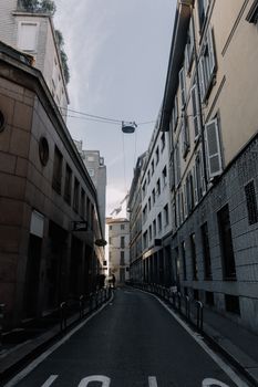 A narrow, quiet street lined with tall buildings, showcasing modern architecture in a city setting.