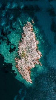 Scenic aerial view of a rocky island surrounded by turquoise ocean water near Conway, SC.