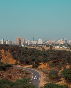 Image shows farmers protesting on a highway in Haryana during a land dispute. Police presence is visible. National news.