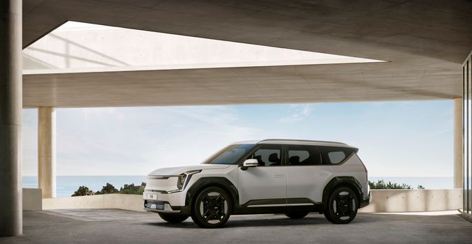 A luxurious white SUV showcased in a minimalist, concrete architectural setting with sea view.