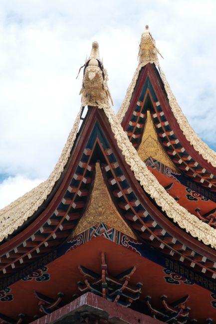 Close-up of intricate Tibetan temple roof details showcasing vibrant colors and traditional design.