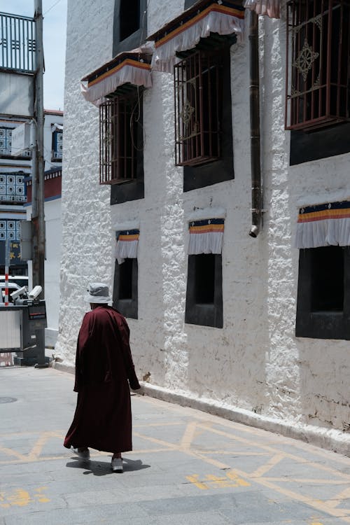 Woman in Hat Walking on Sunlit Street