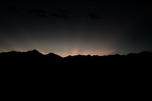 Serene mountain silhouette against the dimming twilight sky, capturing nature's tranquil beauty.