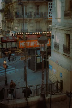Vintage view of a Paris street featuring a Metro sign, capturing city life and architecture.