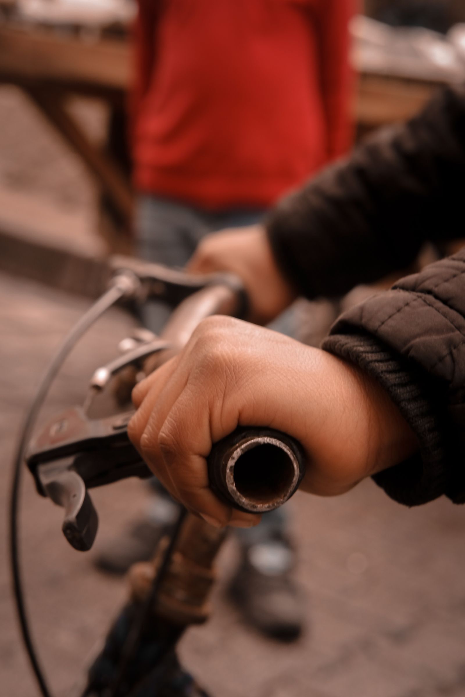 Cyclist hand and wrist on bicycle handlebars for mountain biking wrist brace selection. Photo: Pexels.