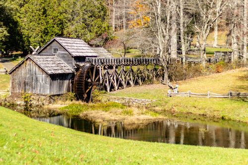 Free Explore the picturesque Mabry Mill in Virginia with its iconic water wheel surrounded by lush greenery. Stock Photo