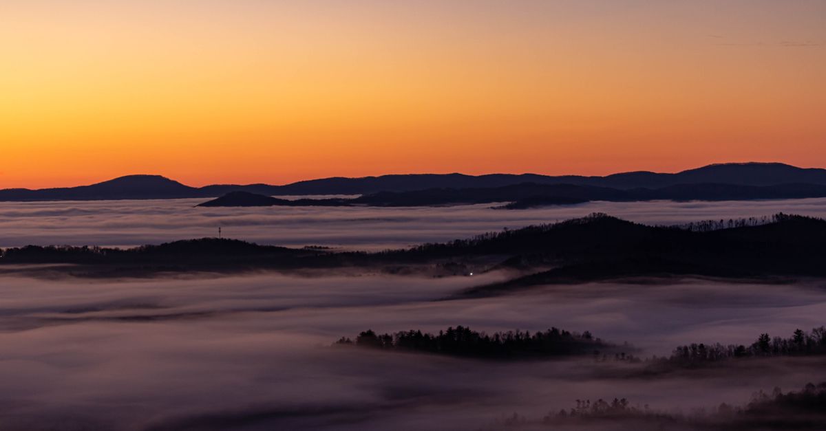 Capture the serene beauty of sunrise over fog-shrouded Appalachian mountains in Boone, NC.