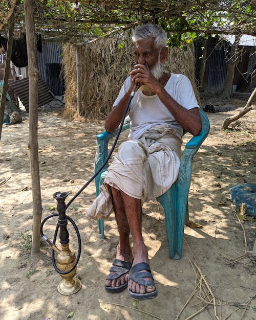 Man Sitting and Smoking Hookah