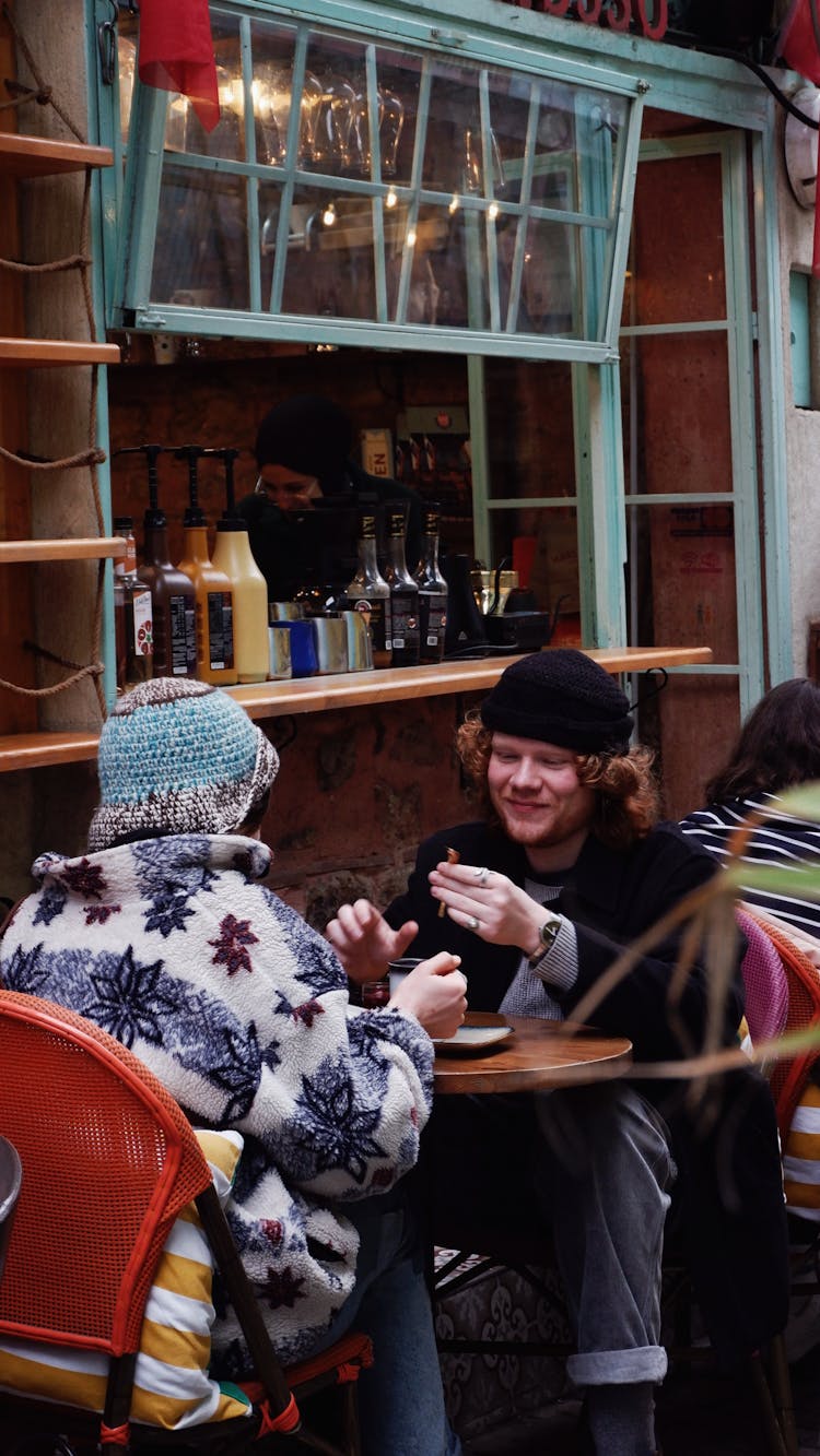 Couple At The Table In Front Of Street Food Stall