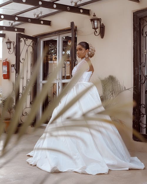 Bride in a Long White Wedding Dress with Chiffon Sleeves Posing on the Patio