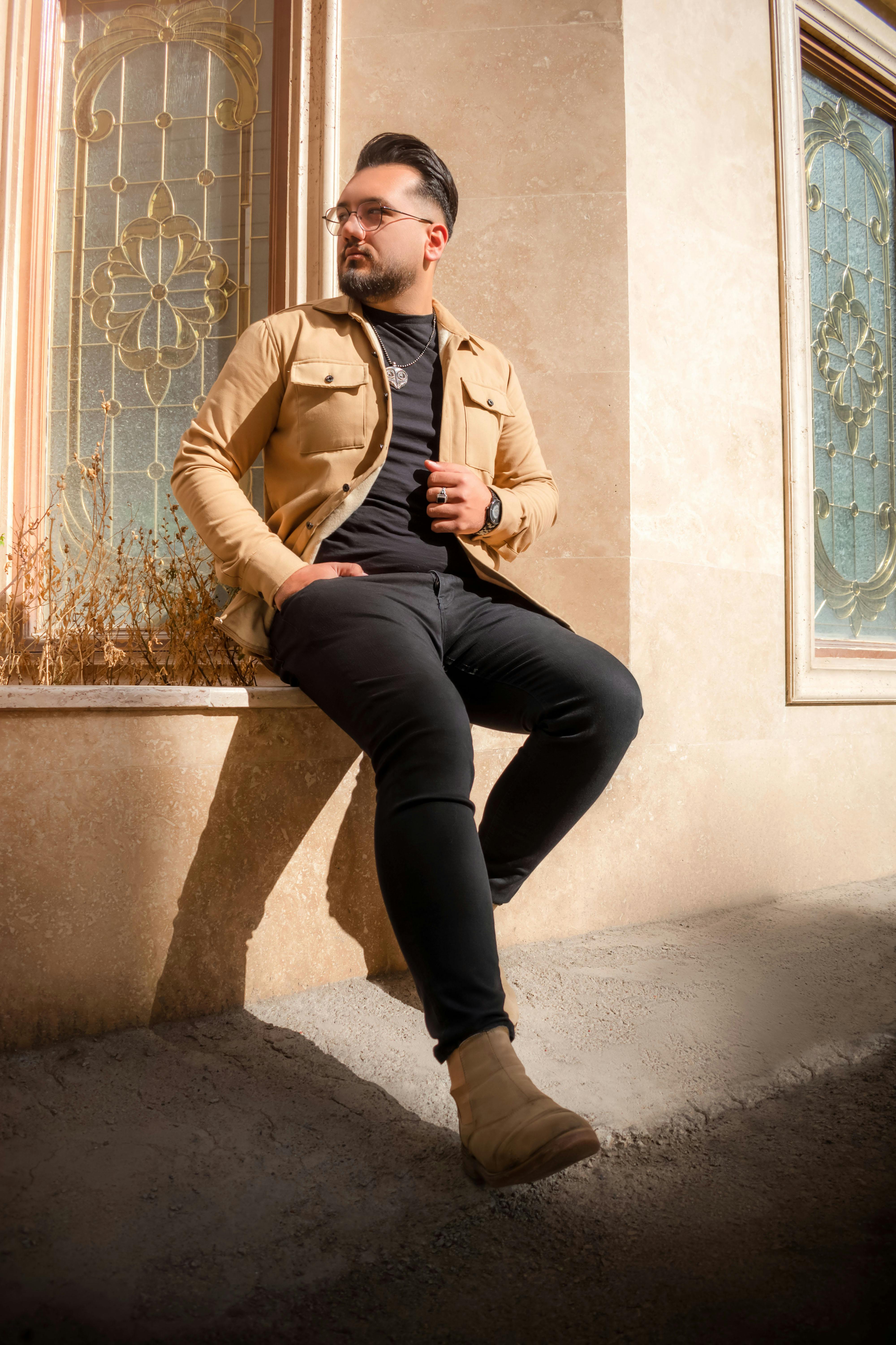 a man sitting on a ledge in front of a building