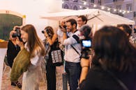 在葡萄牙里斯本一条热闹的街道上，一群充满活力的摄影师正在拍照