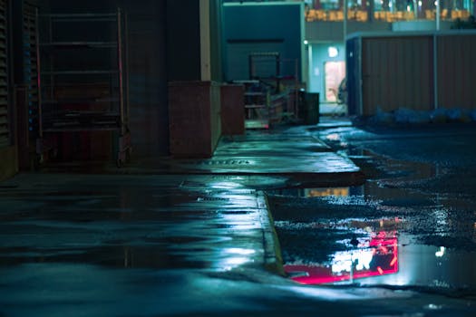 Cinematic urban street scene at night with wet pavement and reflections.