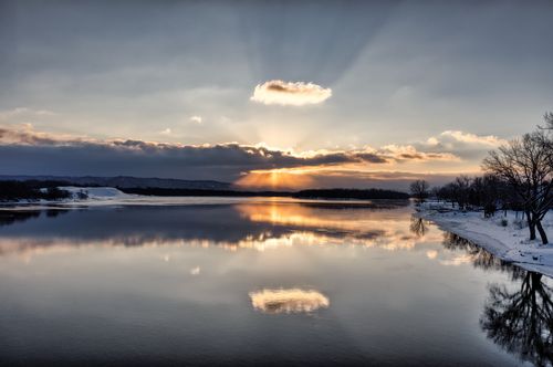 Free Serene winter sunrise over a frozen lake in Wabasha, Minnesota reflecting colorful skies. Stock Photo