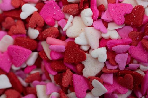 Free Colorful heart-shaped candy sprinkles in red and pink, perfect for Valentine's Day themes. Stock Photo