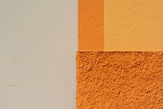 Close-up of a brightly colored geometric wall with orange and yellow hues.
