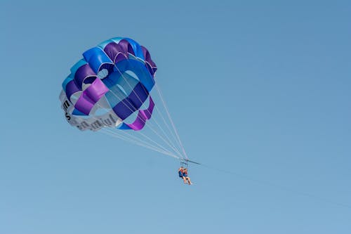People Parachuting under Clear Sky