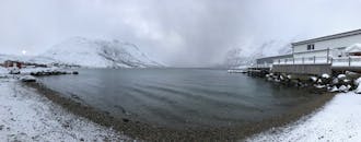 挪威特隆斯特白雪皑皑的峡湾，以其宁静的雪山景观，展现出令人惊叹的冬日风光