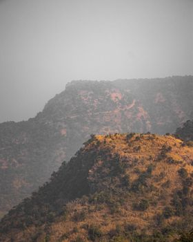 Scenic view of rugged mountains under overcast skies, creating a moody atmosphere.