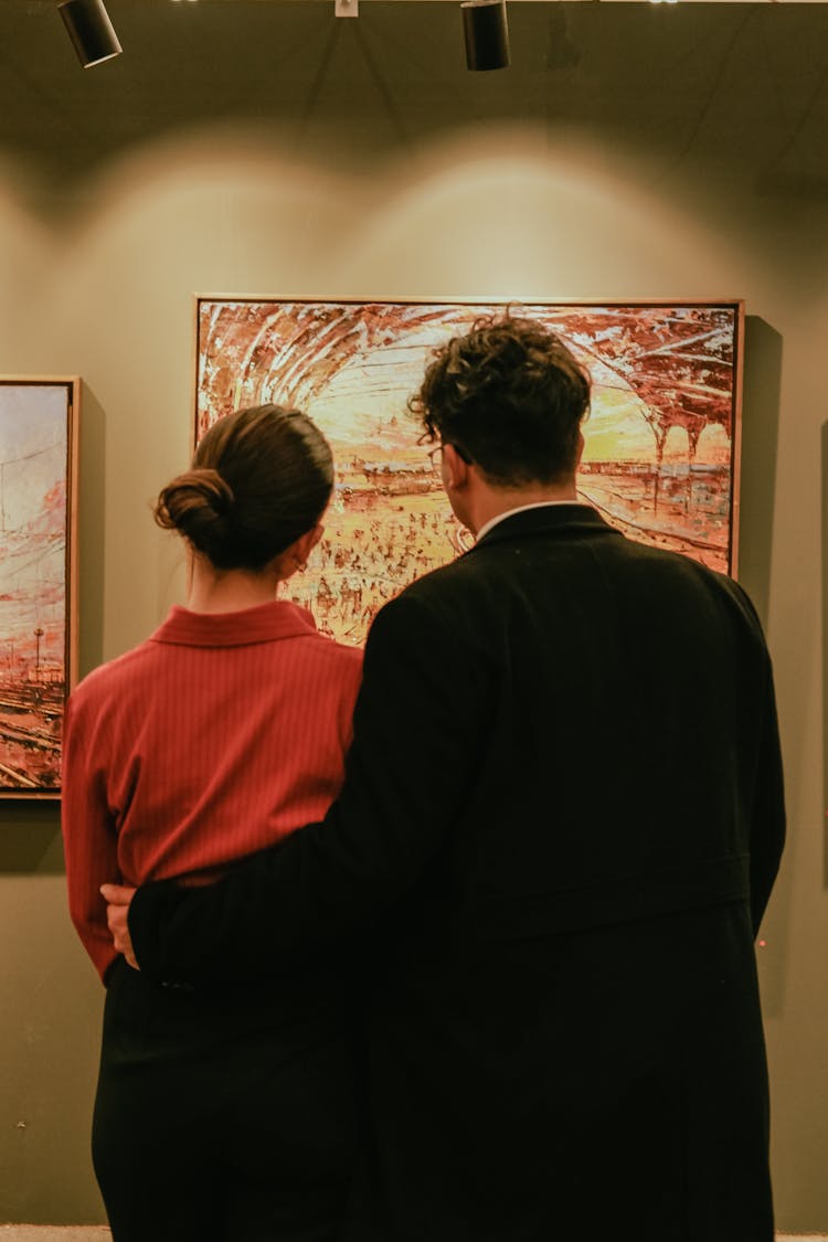 Woman And Man Watching Painting On Exhibition