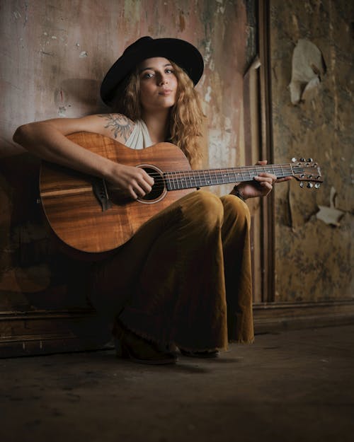 Young Woman in Cowboy Hat Playing Guitar