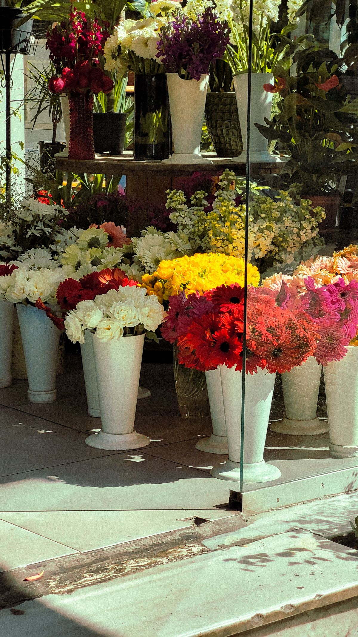 Colorful flower arrangements displayed in vases at a florist shop.
